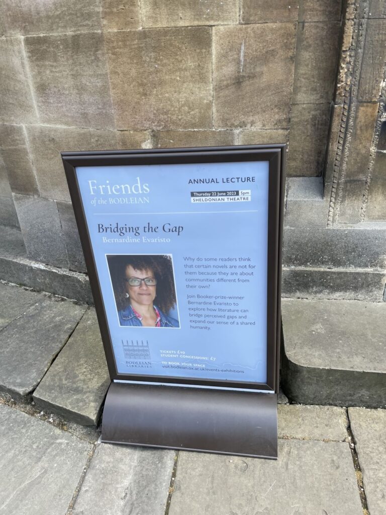 A poster on an Oxford sidewalk advertising Bernardine Evaristo's appearance at the Sheldonian Theatre